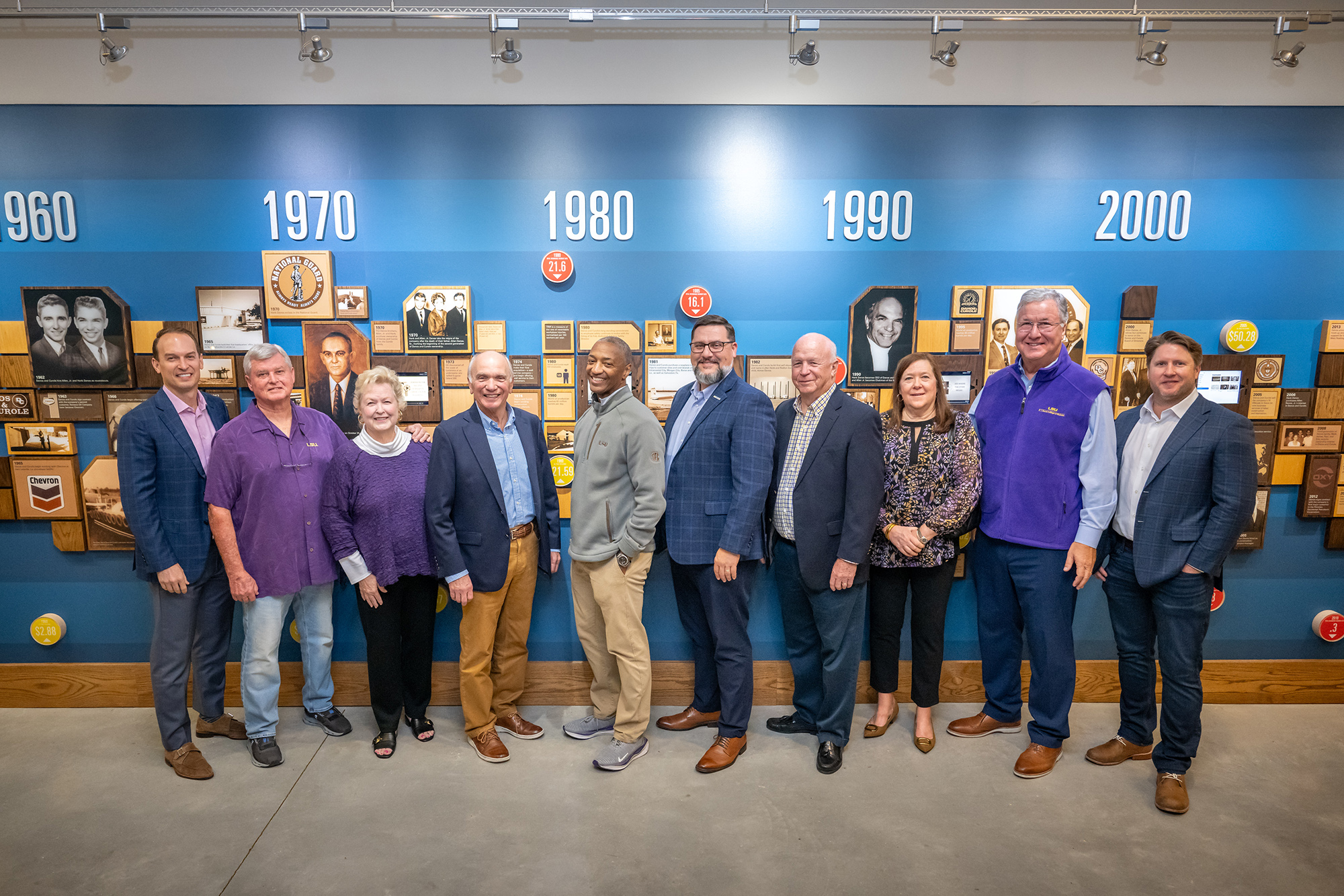 Danos family members and William F. Tate state in front of a timeline of the corporation.