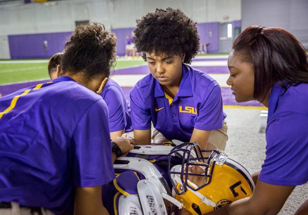 Athletic Training students assisting football player on the ground