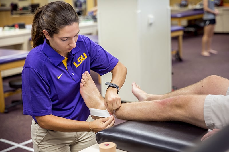 girl wrapping injured ankle